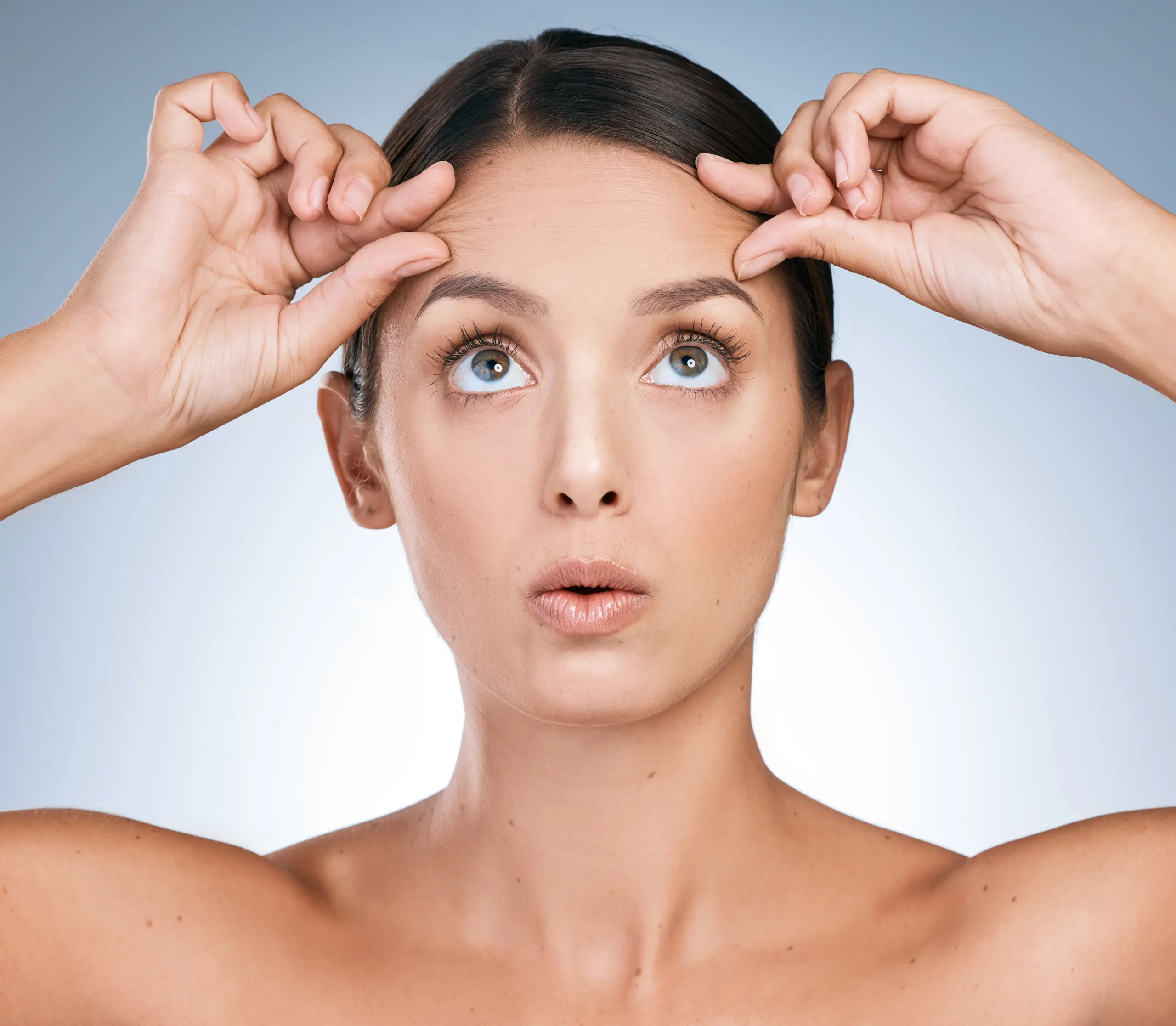 a woman using her fingers to hold up her brows